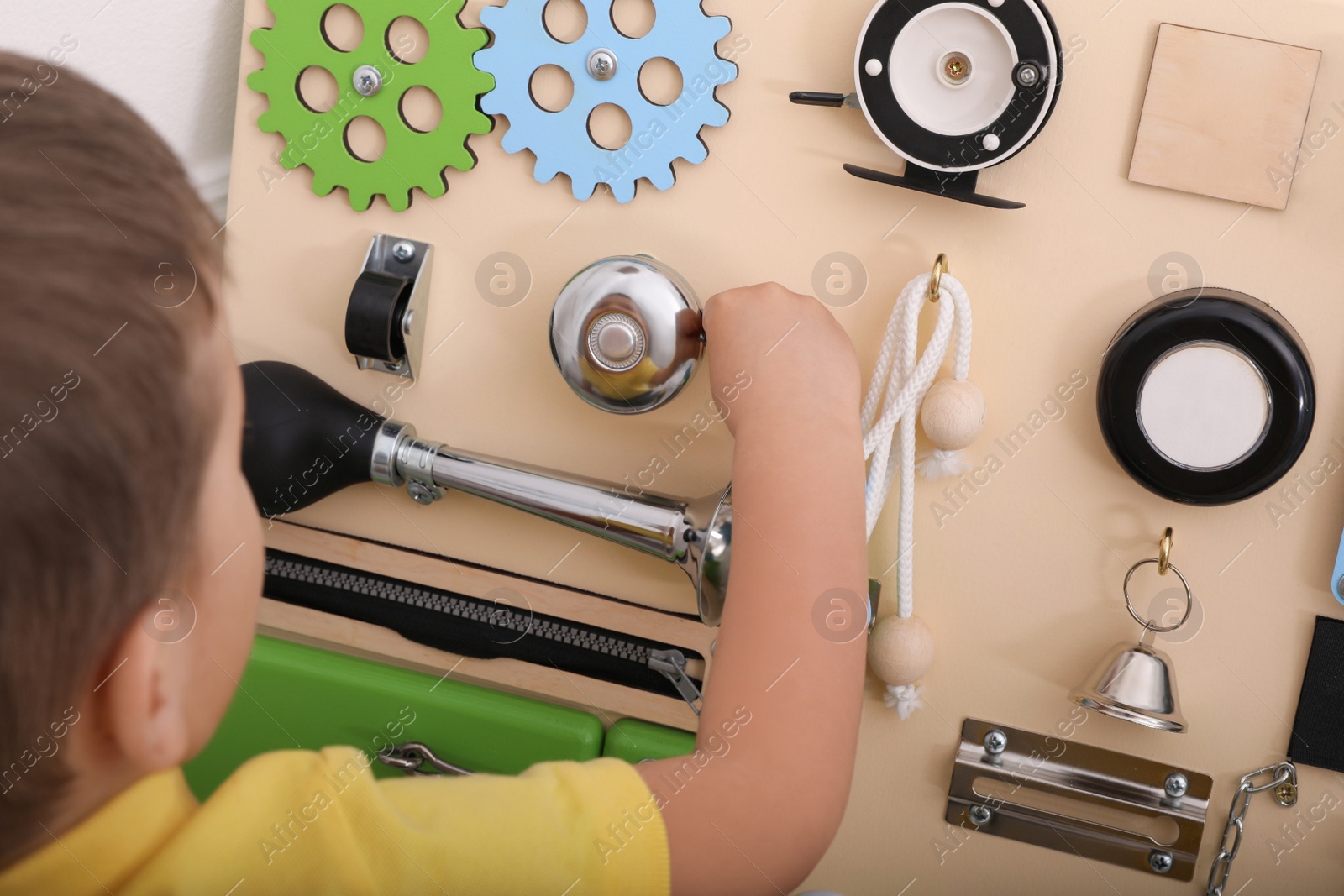 Photo of Little boy playing with busy board, focus on hand