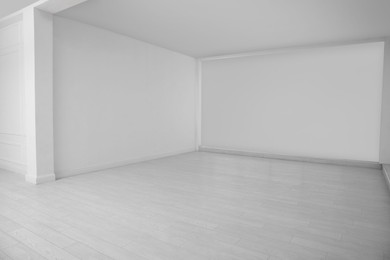 Photo of Empty room with white walls and laminated floor
