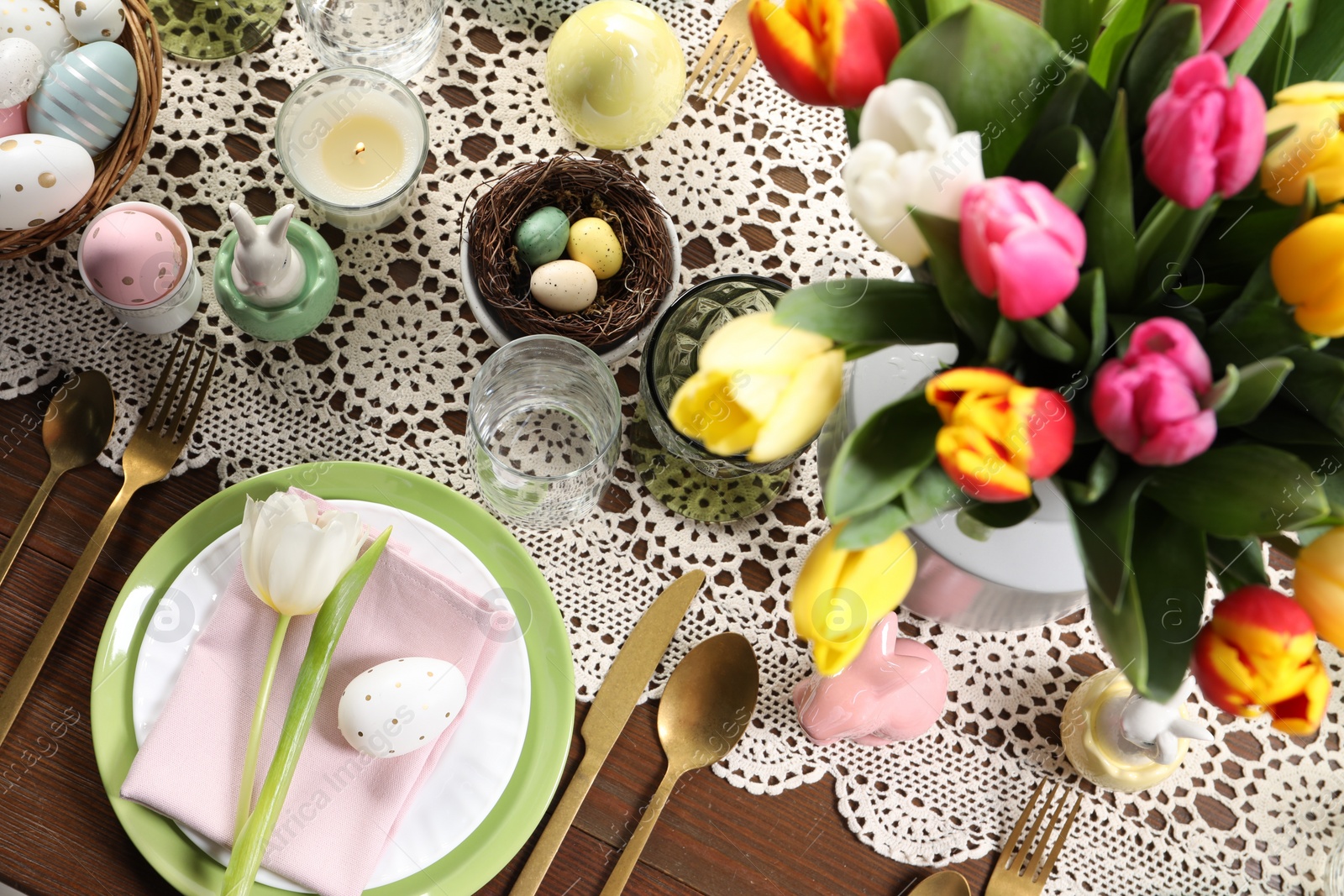 Photo of Festive table setting with beautiful flowers, flat lay. Easter celebration