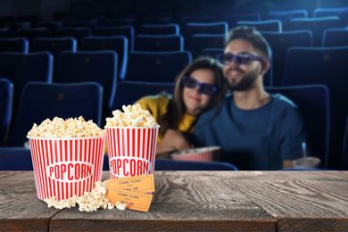 Image of Popcorn, tickets on table and young couple in cinema hall