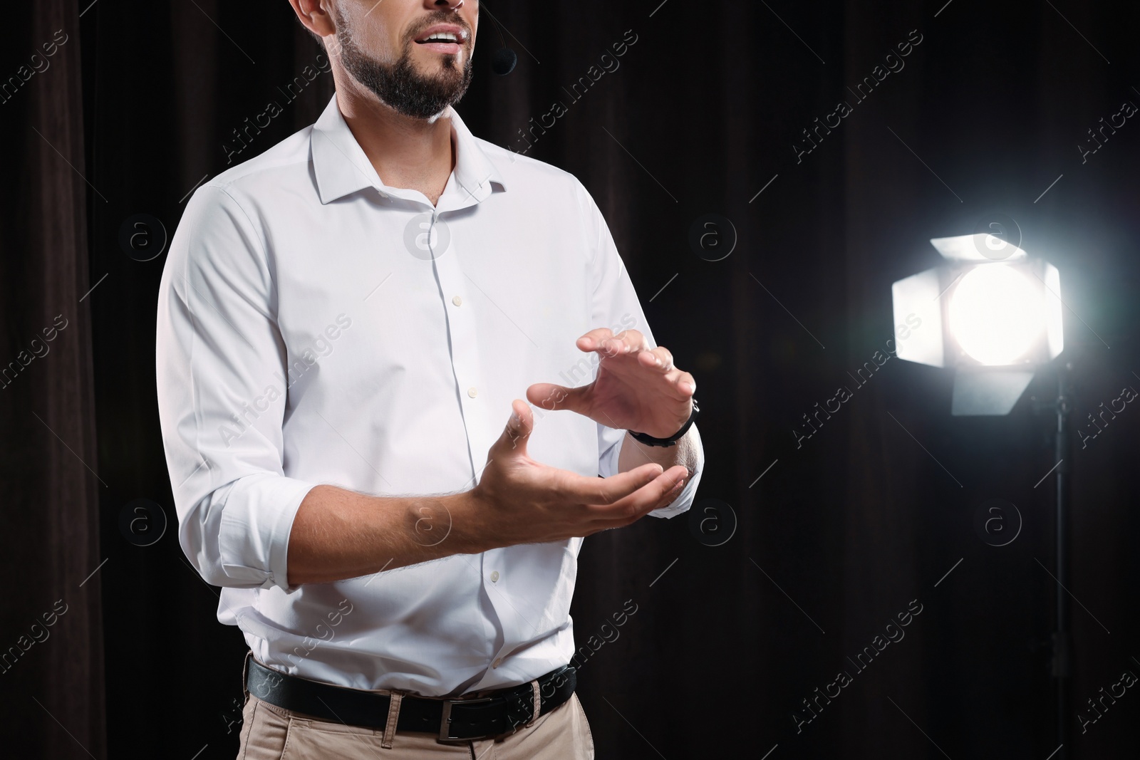 Photo of Motivational speaker with headset performing on stage, closeup. Space for text