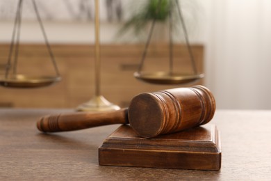 Wooden gavel and sound block on table indoors, closeup