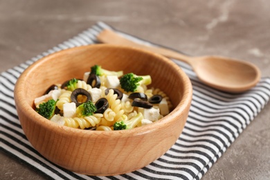 Photo of Wooden bowl with delicious pasta primavera on table