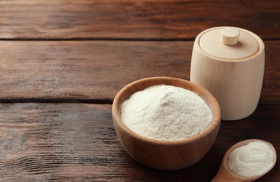 Photo of Bowl, box and spoon of agar-agar powder on wooden table, space for text