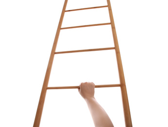 Photo of Woman climbing up wooden ladder against white background, closeup