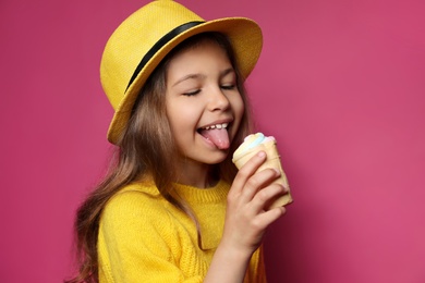 Photo of Adorable little girl with delicious ice cream against color background