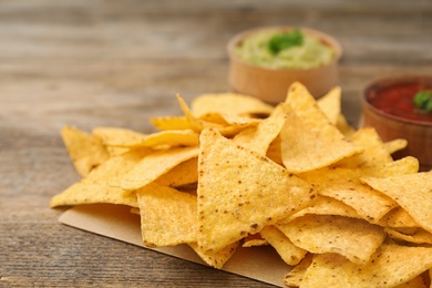 Mexican nacho chips on wooden table, closeup