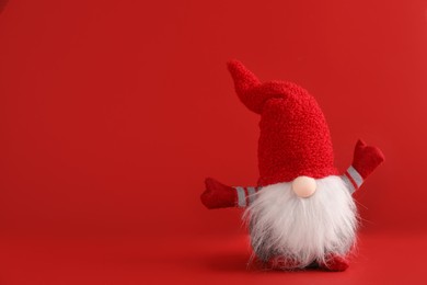 Photo of Cute Christmas gnome on red background. Space for text