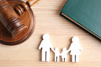 Family law concept. Judge gavel, family figure and book on wooden background, flat lay 