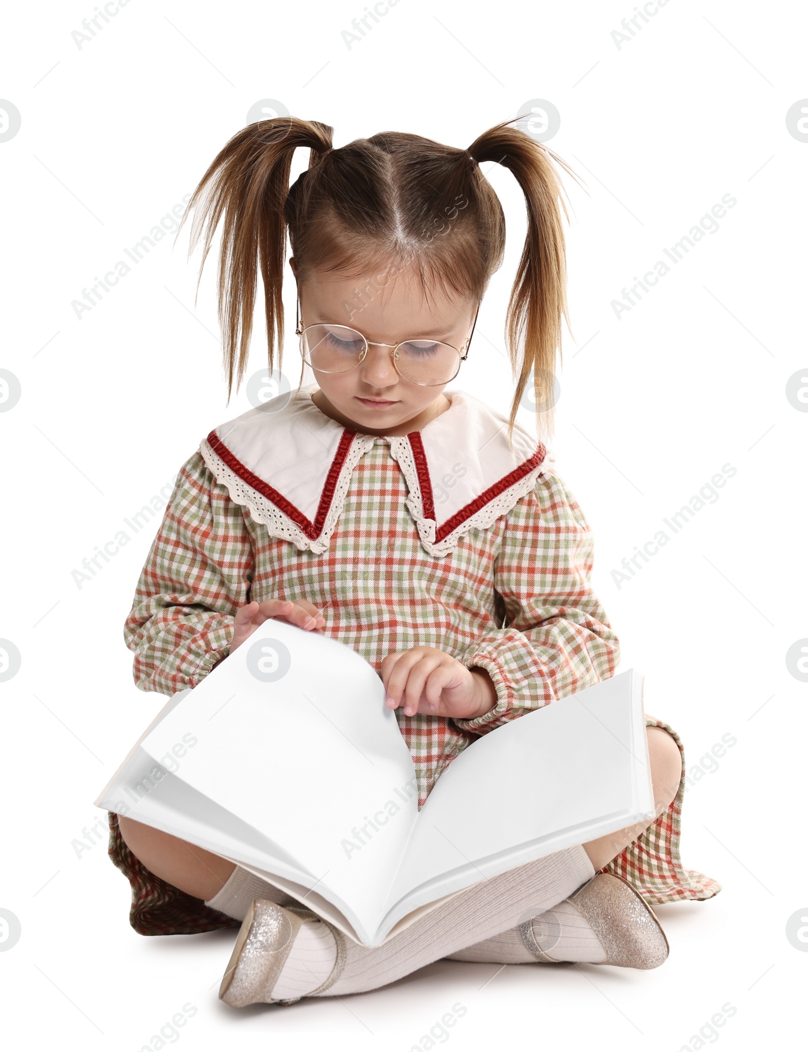 Photo of Cute little girl reading book on white background