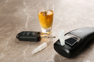 Photo of Composition with modern breathalyzer on brown marble table