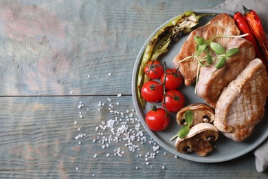 Photo of Delicious grilled meat and vegetables served on wooden table, flat lay. Space for text