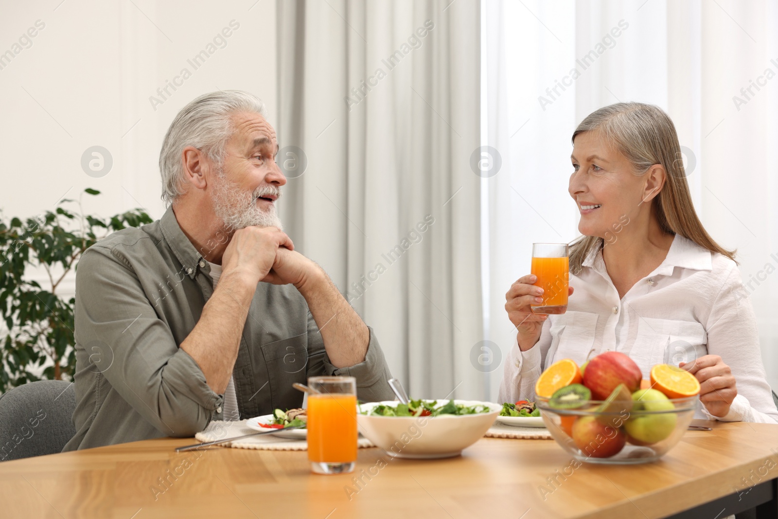 Photo of Happy senior couple having dinner at home