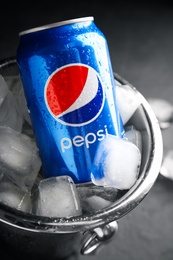 MYKOLAIV, UKRAINE - FEBRUARY 11, 2021: Can of Pepsi and ice cubes in bucket, closeup