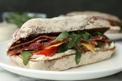 Photo of Delicious sandwich with fresh vegetables and prosciutto on table, closeup view