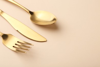 Photo of Stylish cutlery set on beige table, space for text