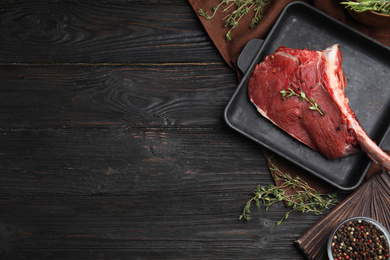 Photo of Flat lay composition with fresh beef cut on wooden table. Space for text