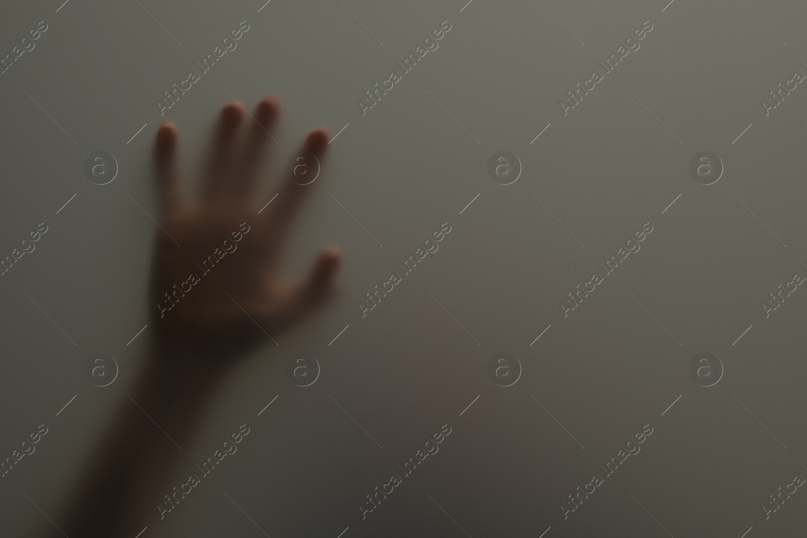 Photo of Silhouette of creepy ghost behind glass against grey background, closeup. Space for text