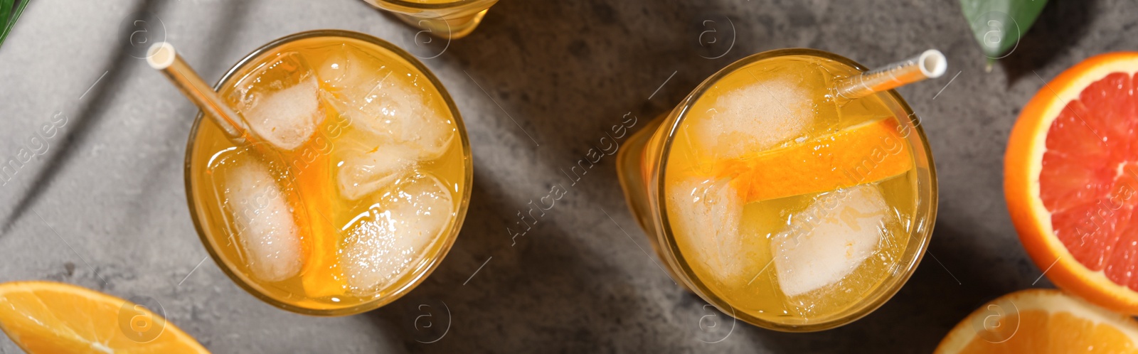 Image of Delicious orange soda water on grey table, flat lay. Banner design