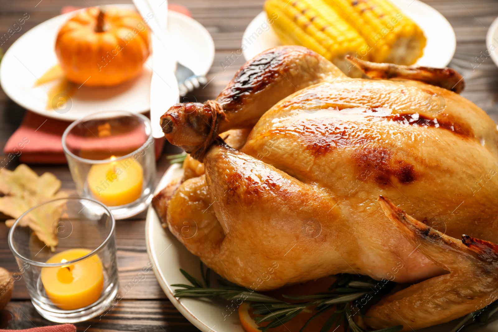 Photo of Traditional Thanksgiving day feast with delicious cooked turkey and other seasonal dishes served on wooden table, closeup