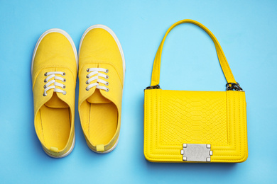 Photo of Stylish woman's bag and shoes on light blue background, flat lay