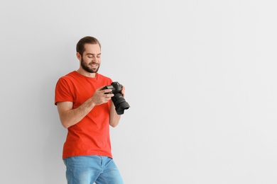 Photo of Young photographer with professional camera on white background