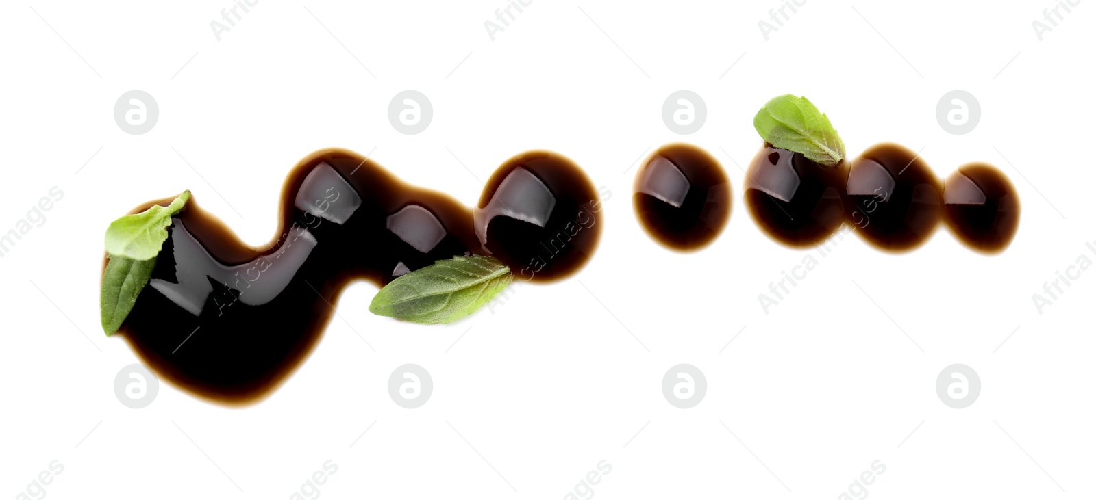 Photo of Balsamic glaze and basil leaves on white background, top view