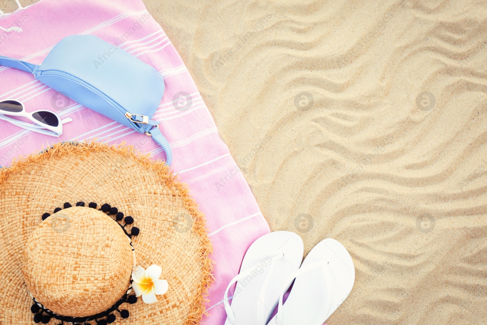 Photo of Flat lay composition with beach accessories on sand, space for text