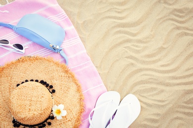 Photo of Flat lay composition with beach accessories on sand, space for text