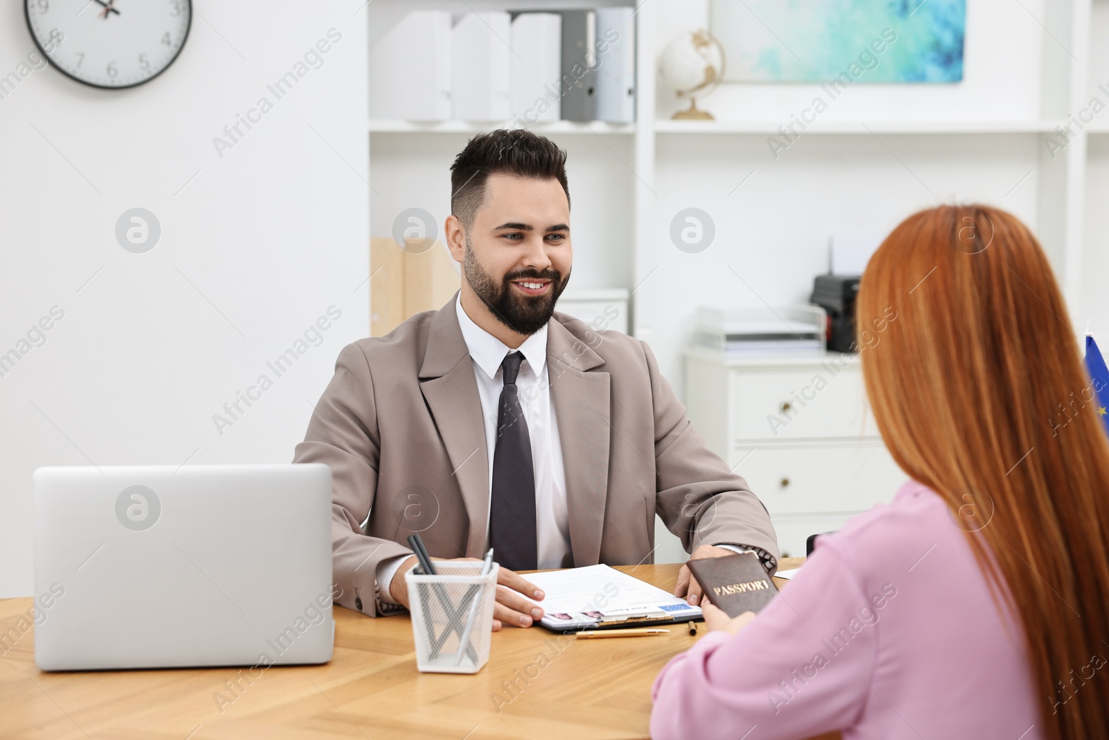 Photo of Immigration. Woman having interview with embassy worker in office