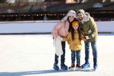 Image of Happy family spending time together at outdoor ice skating rink, space for text