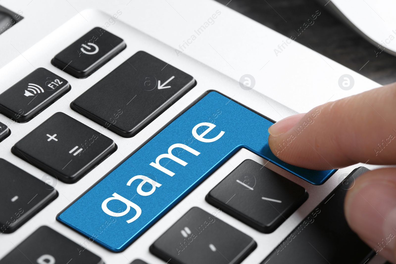 Image of Woman pressing blue button with word GAME on keyboard, closeup