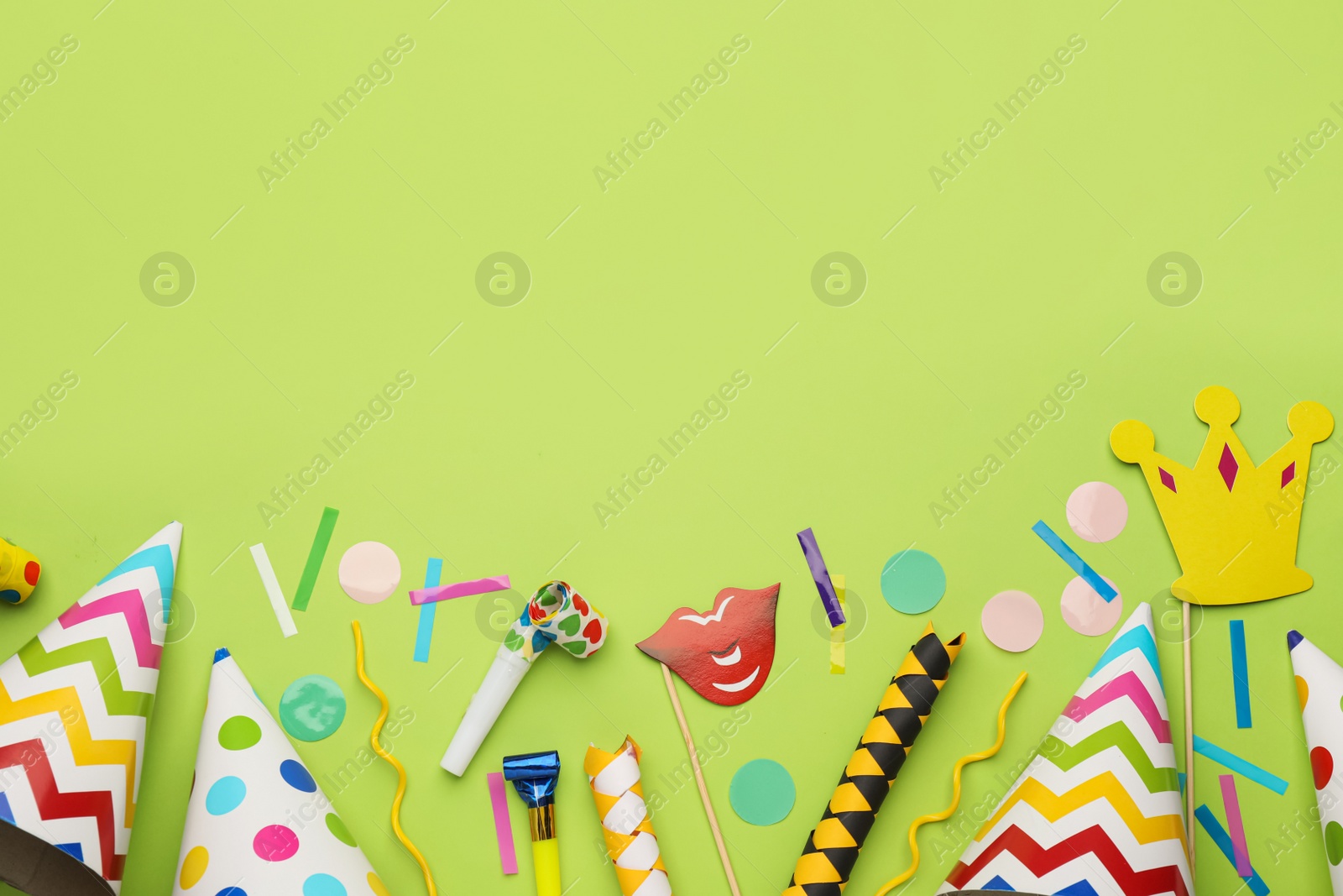 Photo of Flat lay composition with party hats and other festive items on light green background. Space for text