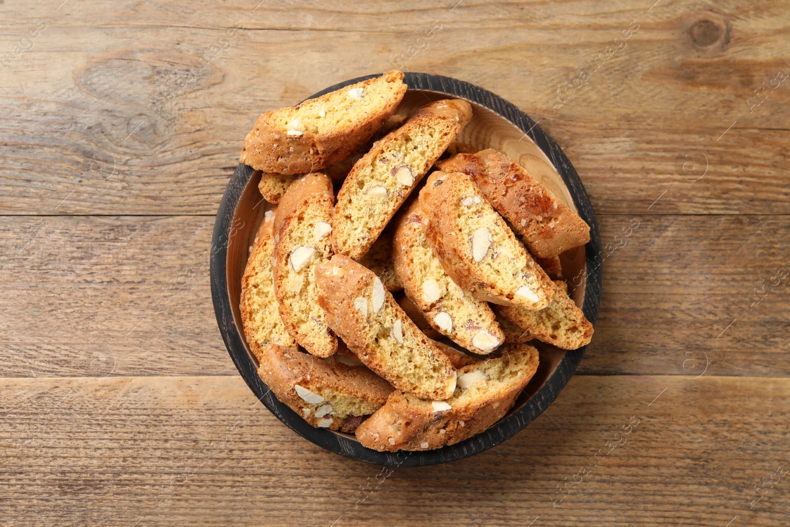 Photo of Traditional Italian almond biscuits (Cantucci) on wooden table, top view