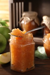 Photo of Delicious apple jam on wooden table, closeup