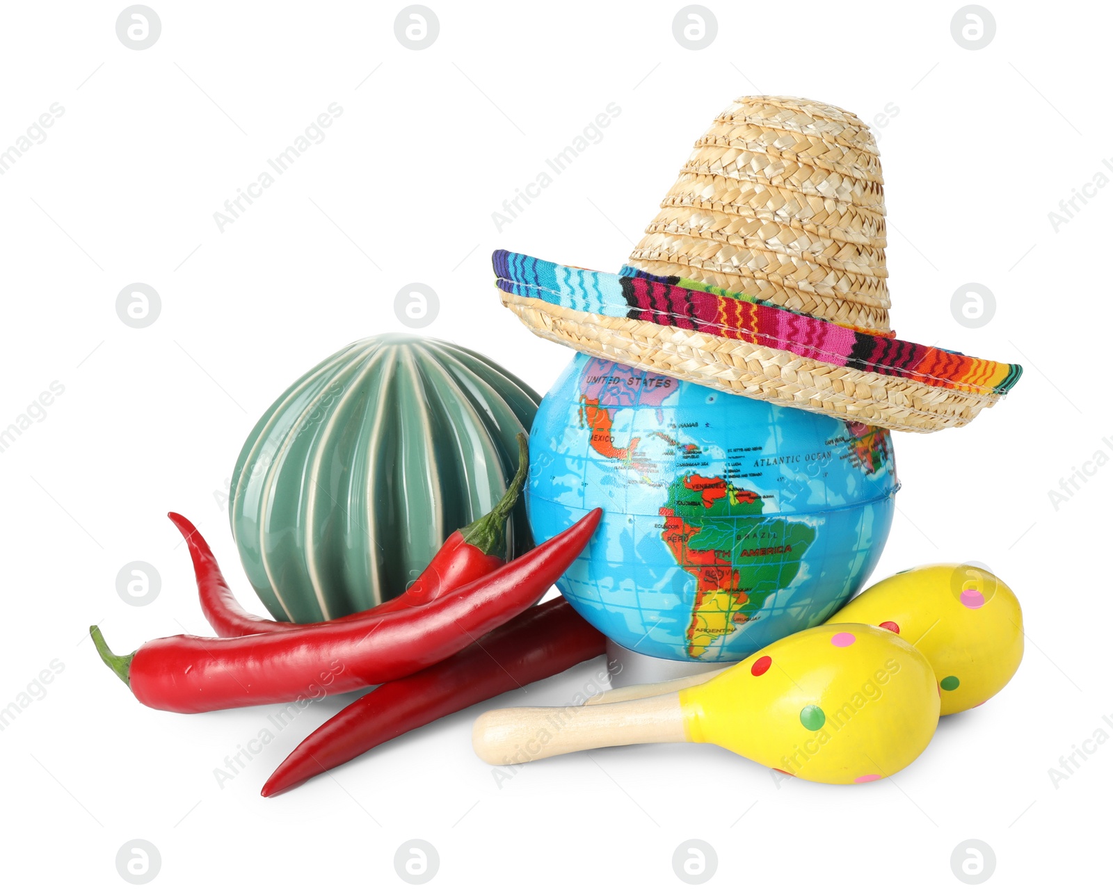 Photo of Globe with Mexican sombrero hat, ceramic cactus, maracas and chili peppers isolated on white