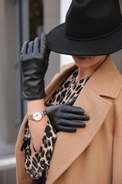 Photo of Young woman in stylish black leather gloves outdoors