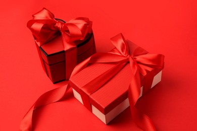 Photo of Beautiful gift boxes with bows on red background