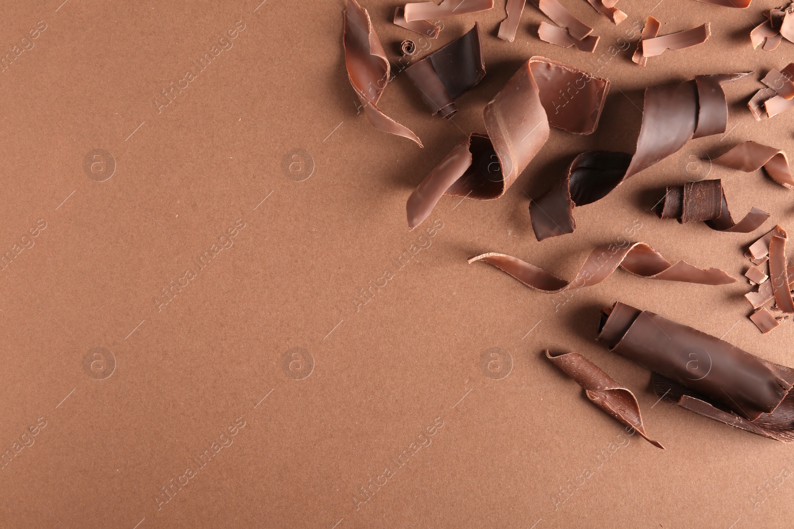 Photo of Yummy chocolate curls and space for text on color background, top view