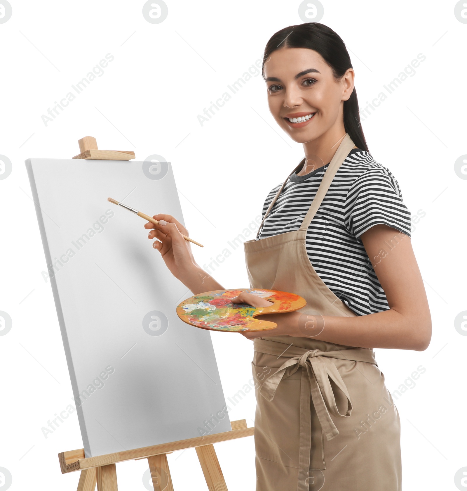 Photo of Young woman drawing on easel against white background