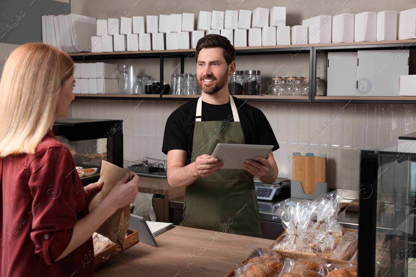 Photo of Woman buying fresh pastries in bakery shop