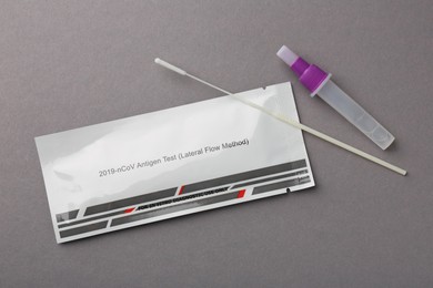 Covid-19 express test kit on gray background, flat lay
