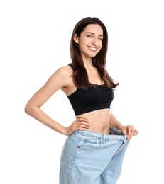 Photo of Happy young woman in big jeans showing her slim body on white background