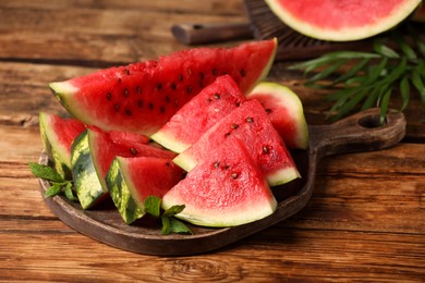 Photo of Slices of delicious ripe watermelon on wooden table