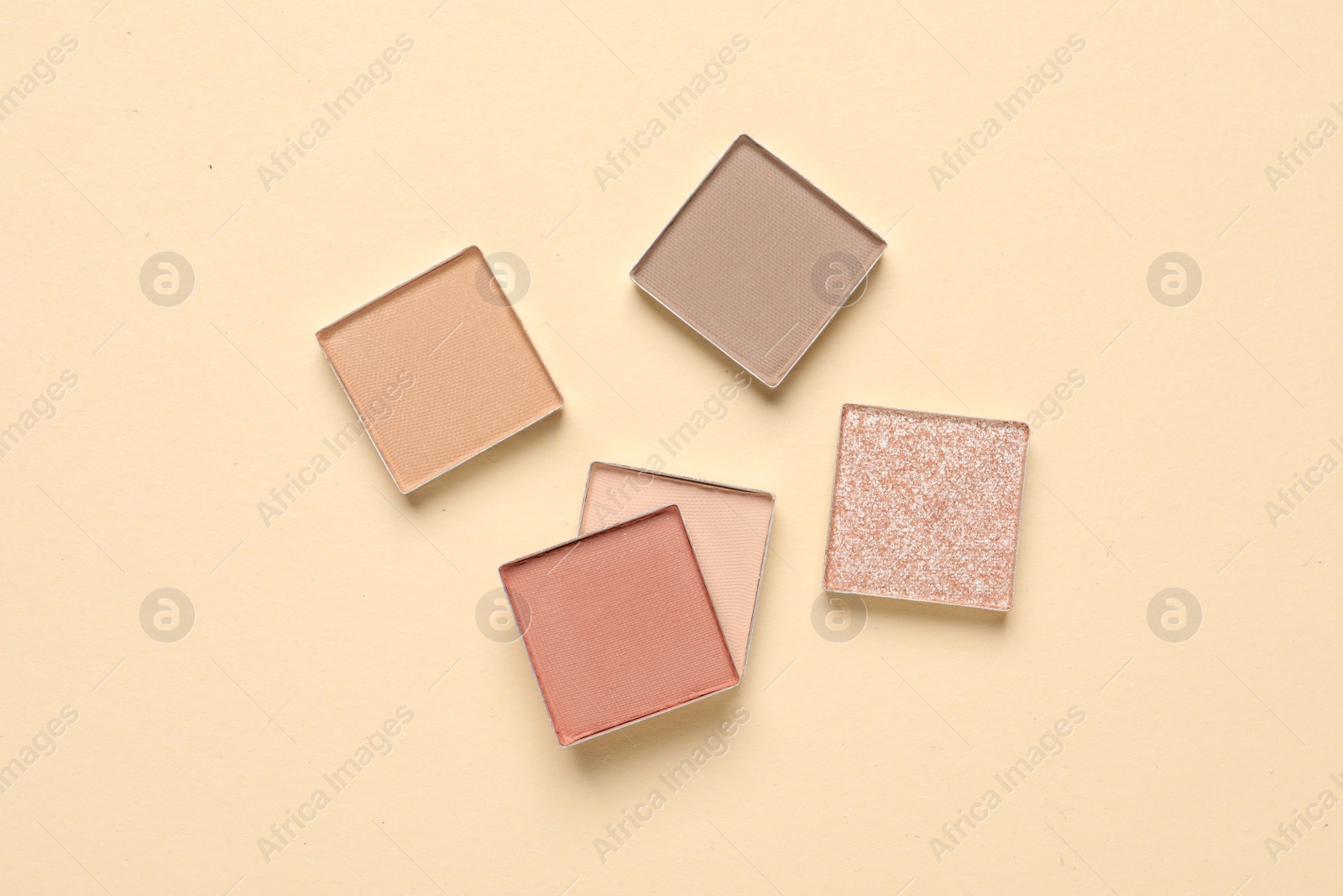 Photo of Different beautiful eye shadows on beige background, flat lay