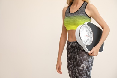 Photo of Woman holding scales on light background. Healthy diet