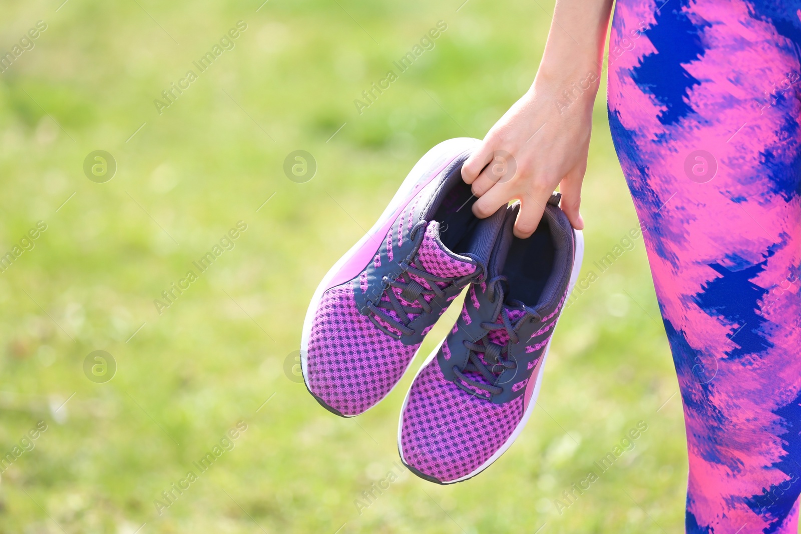 Photo of Young woman with training shoes outdoors, closeup