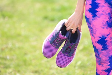 Photo of Young woman with training shoes outdoors, closeup