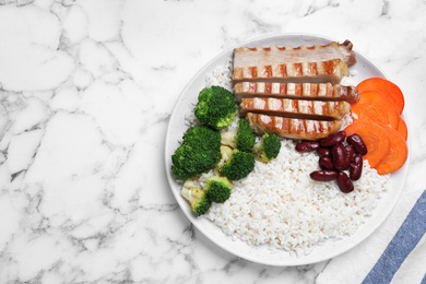 Photo of Delicious rice with beans and meat served on white marble table, top view. Space for text