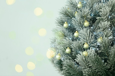 Photo of Beautiful Christmas tree and blurred festive lights on light background. Space for text